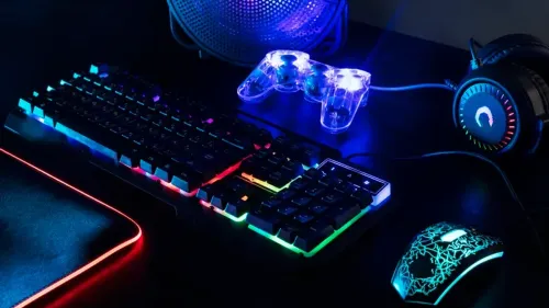 Verlicht gaming toetsenbord en controller bij een beeldscherm zonder merklogo
