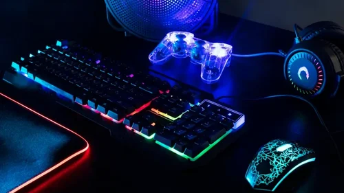 Verlicht gaming toetsenbord en controller bij een beeldscherm zonder merklogo