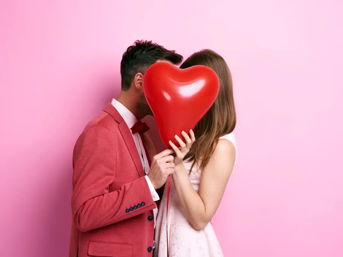 affectionate-couple-covering-face-with-balloon-kissing_15.webp